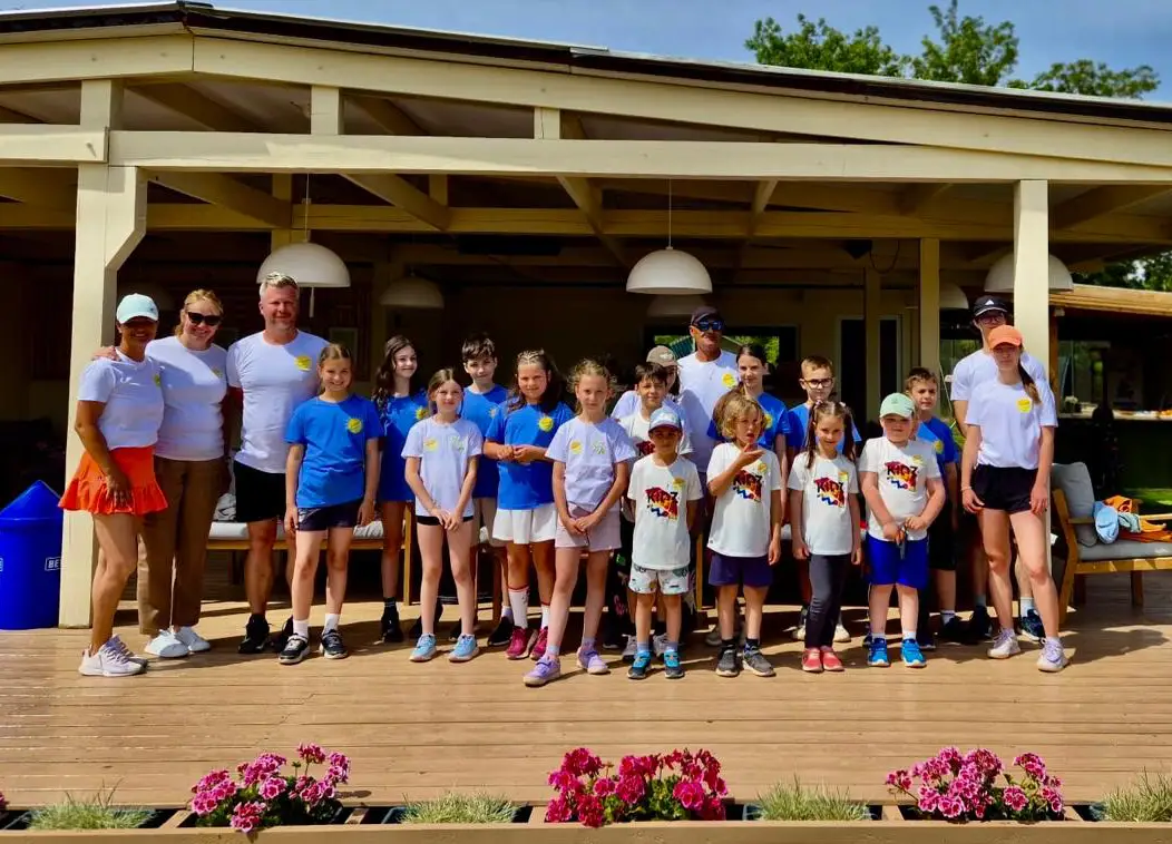 Sunlight Tennis Club coaches and children on the clubhouse terrace